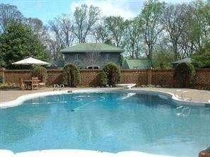 a view of swimming pool with a table and chairs under an umbrella