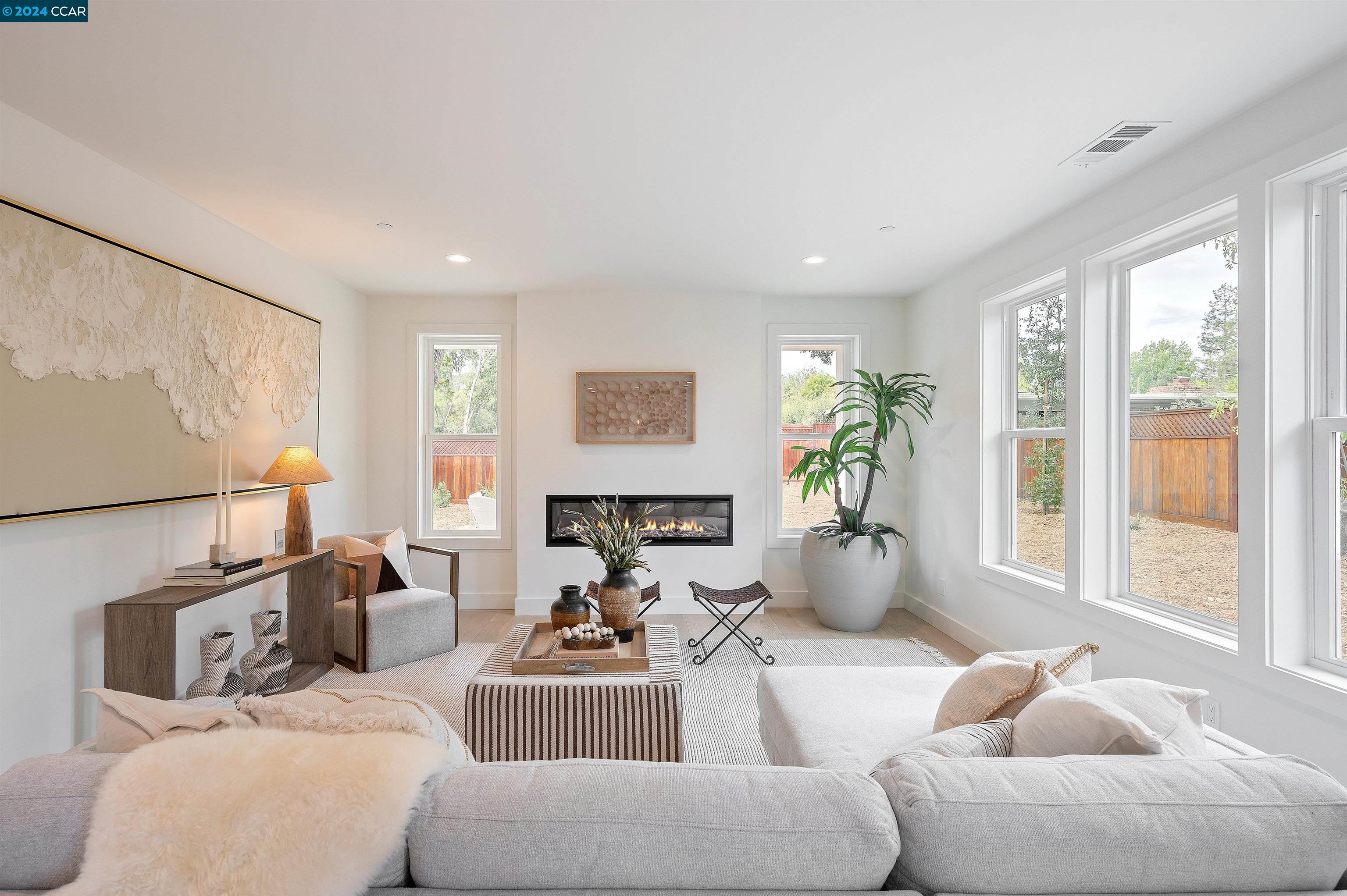 a living room with furniture and floor to ceiling windows