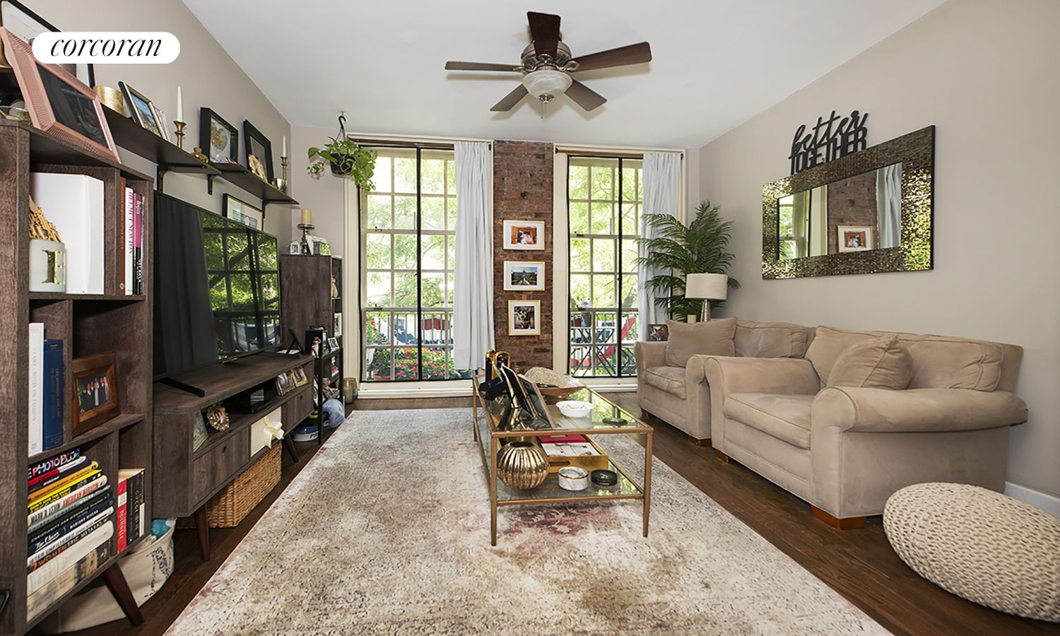 a living room with furniture a flat screen tv and a floor to ceiling window