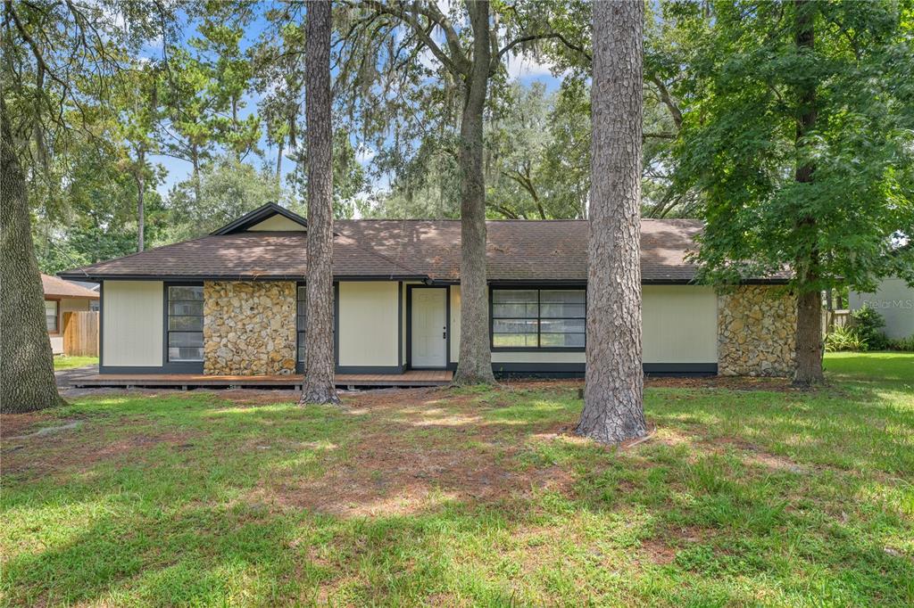 a view of a brick house with a large window and a large tree