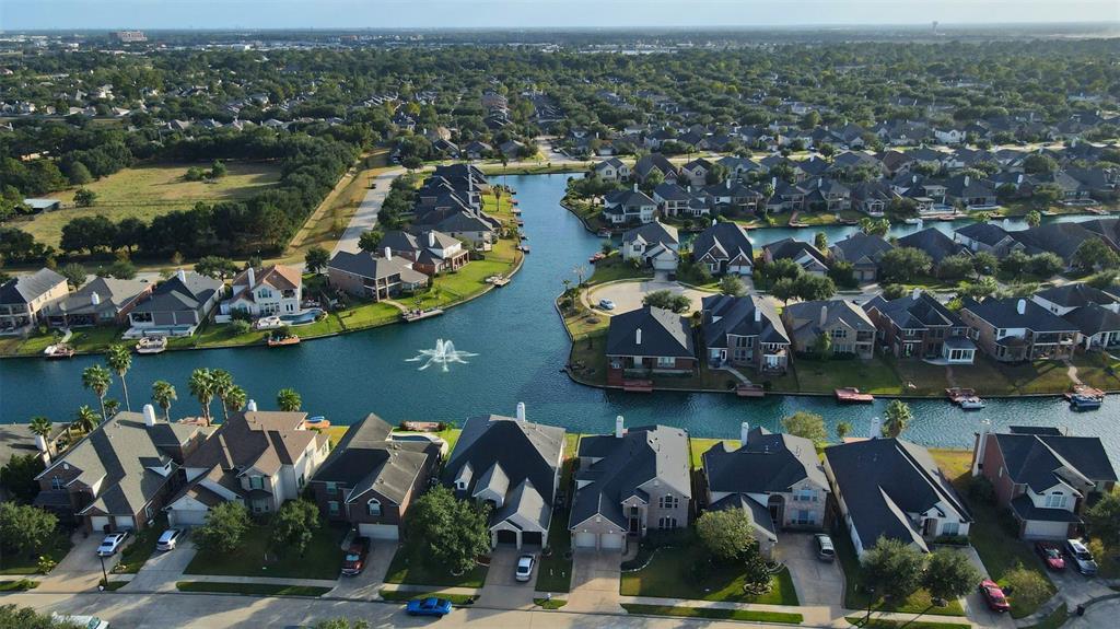 an aerial view of residential houses with outdoor space and lake view