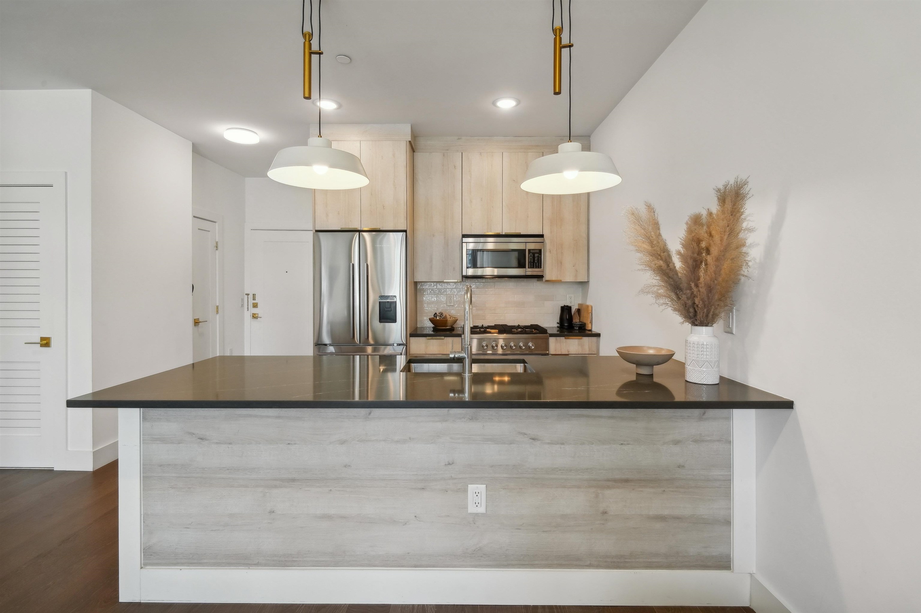 a kitchen with kitchen island granite countertop a sink a counter and cabinets