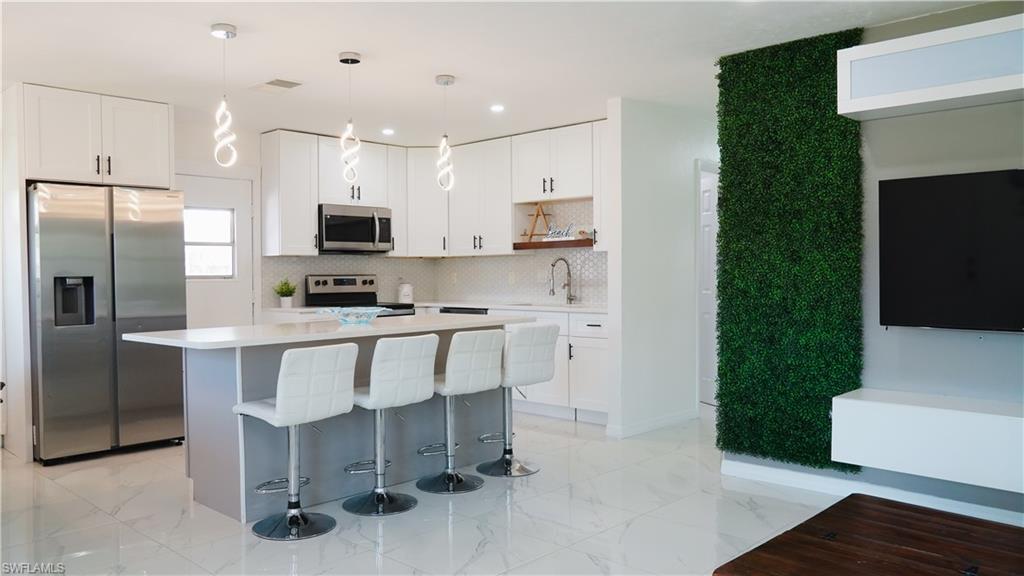 a kitchen with kitchen island a sink stainless steel appliances and cabinets