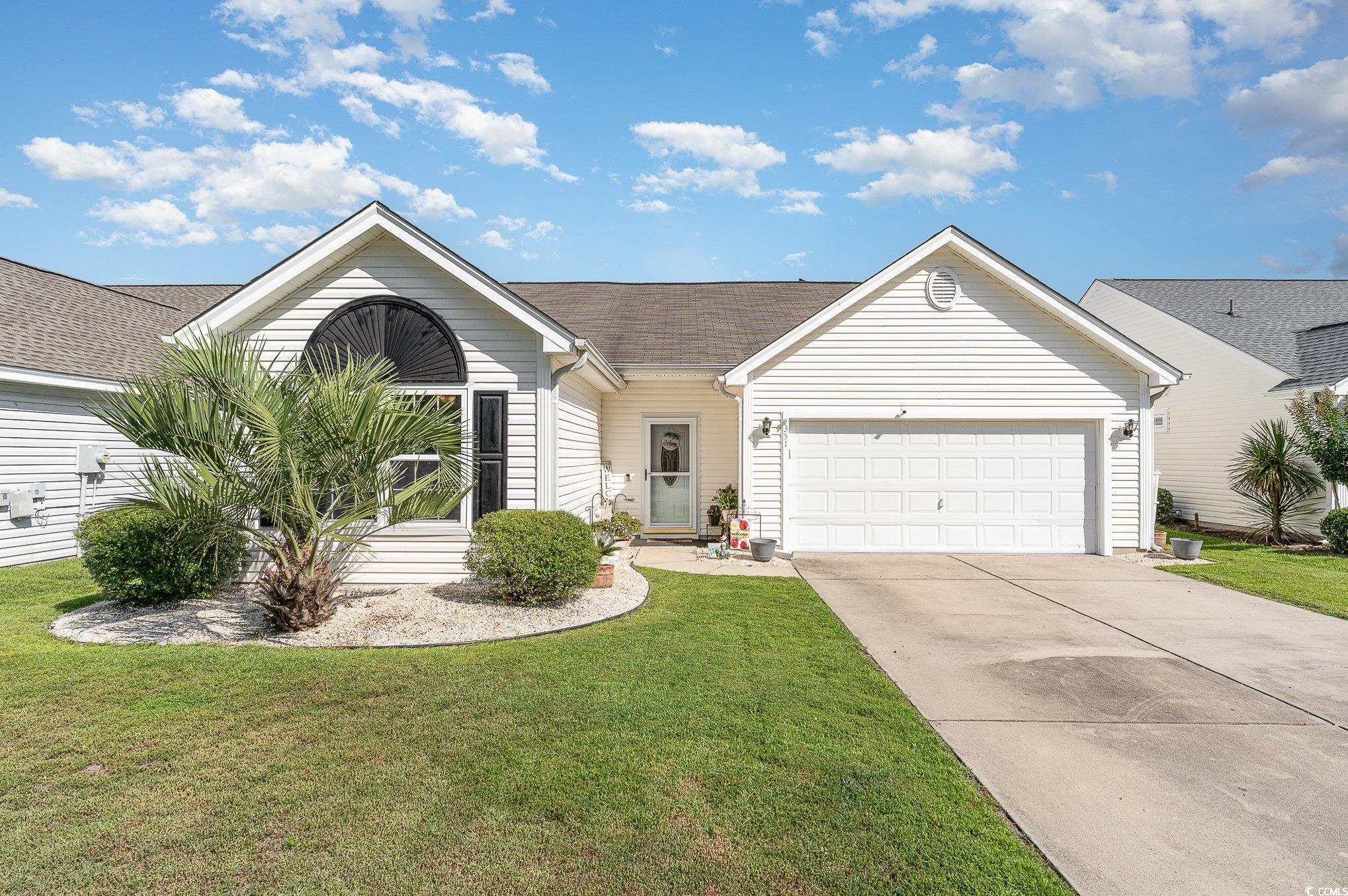 Single story home with a garage and a front lawn