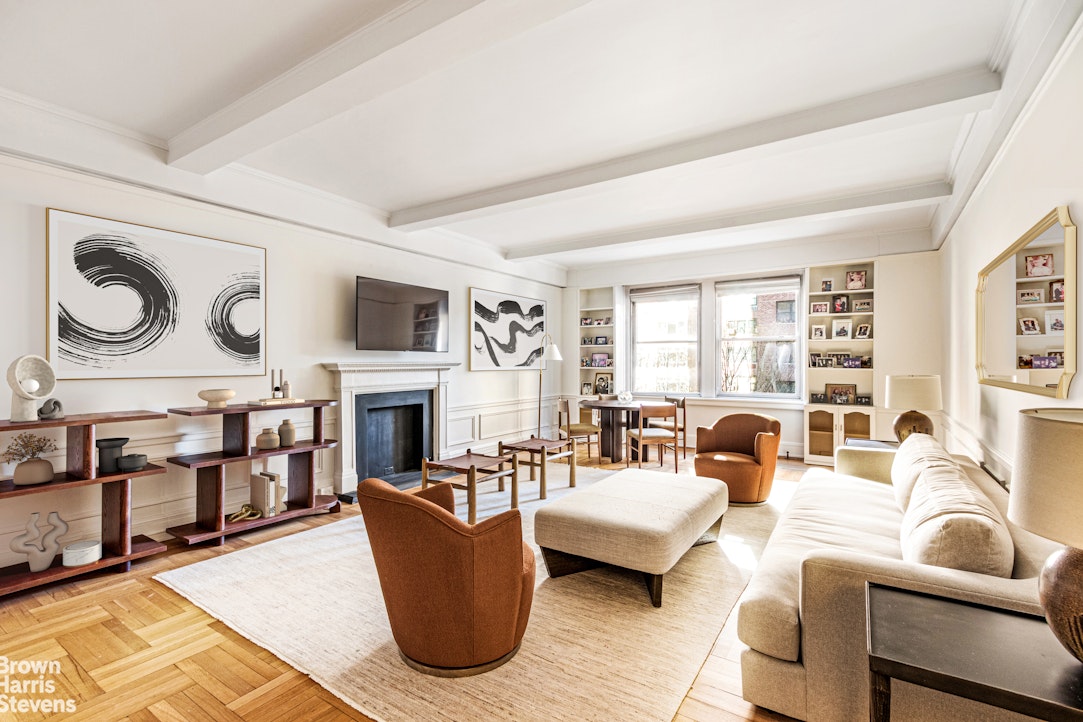 a living room with fireplace furniture and a large window