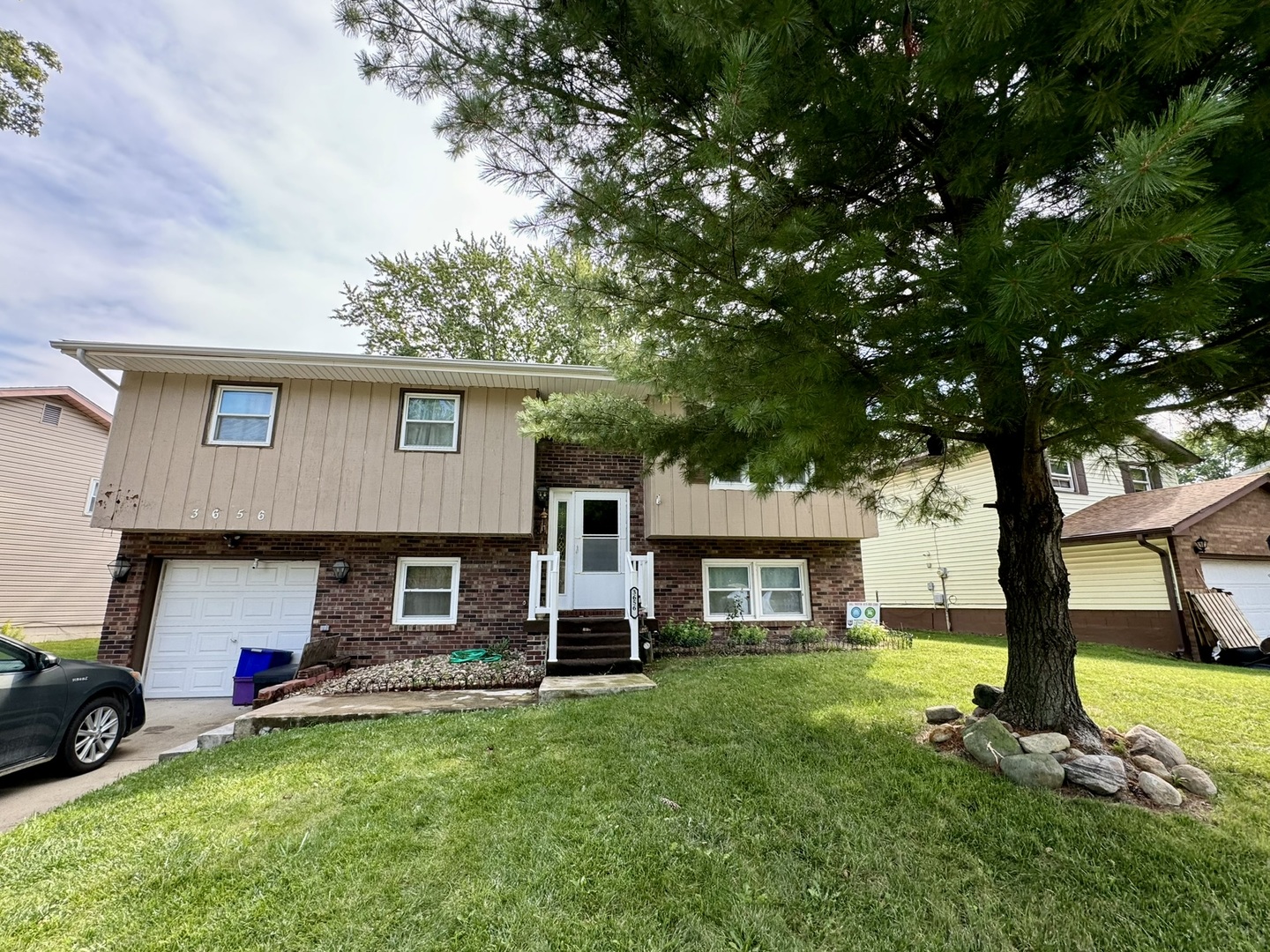 a view of a house with a backyard and a tree