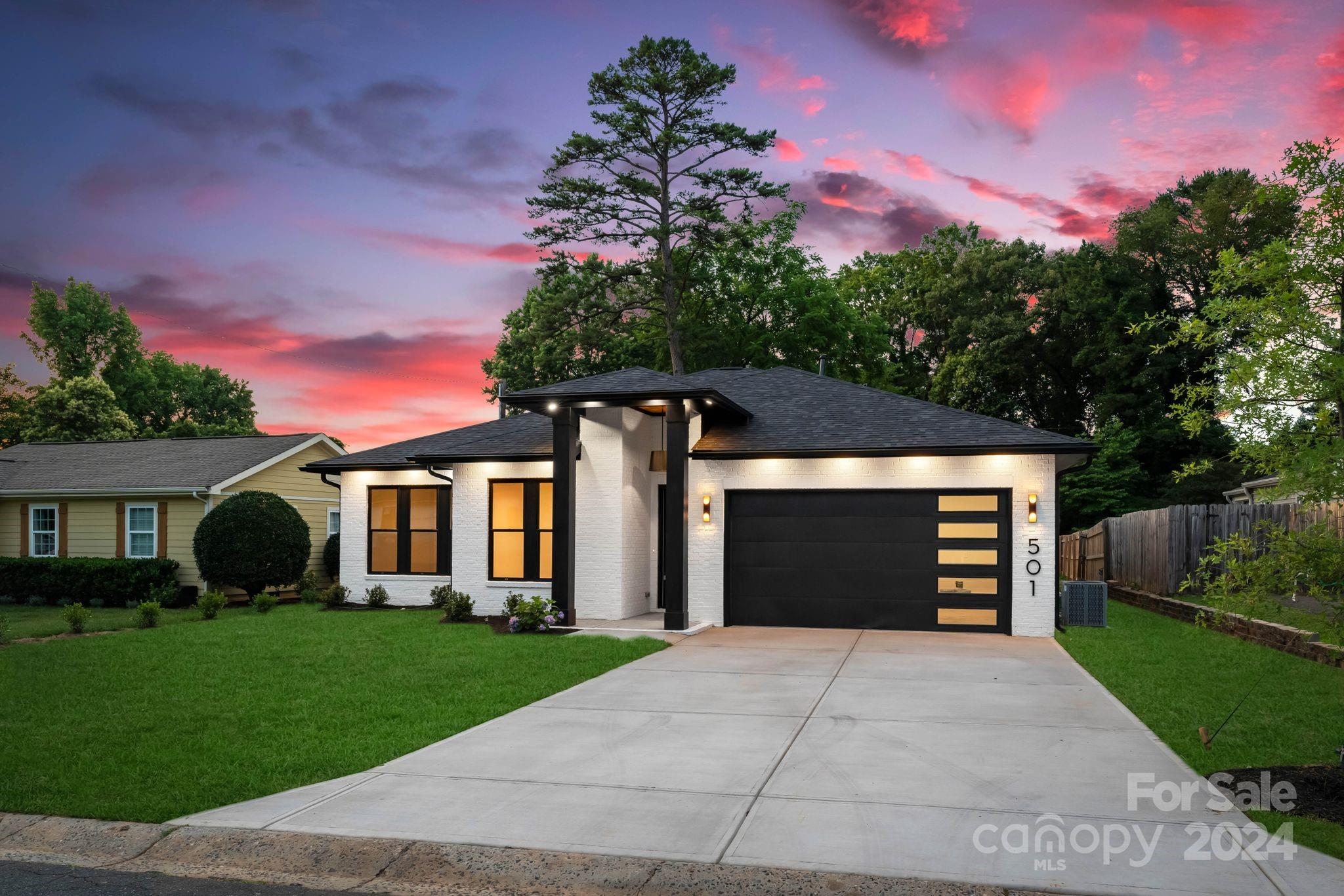 a front view of a house with a yard and a garage