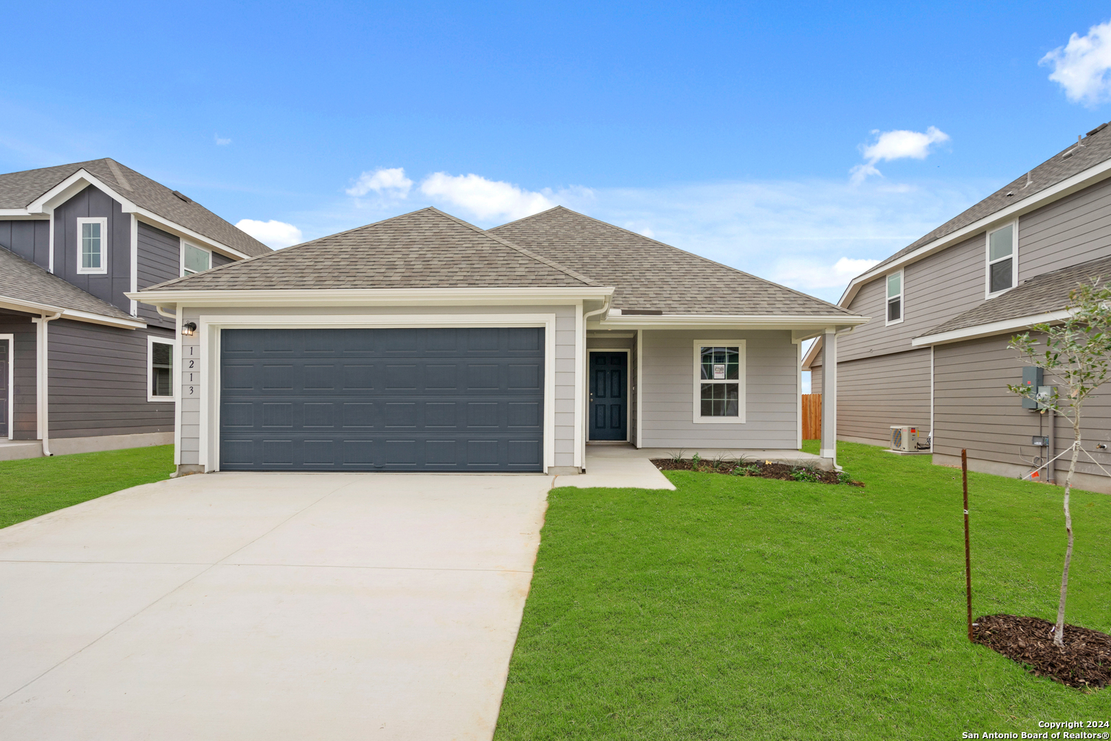 a front view of a house with a yard and garage