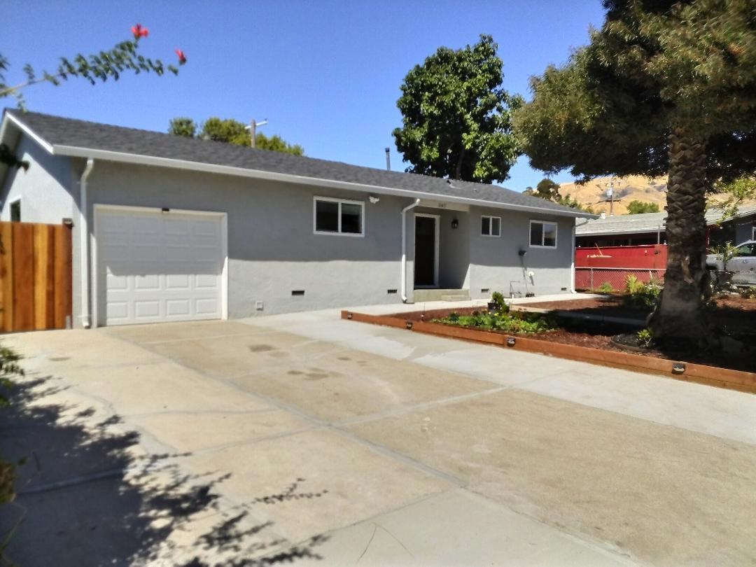 a house with yard and a trees in front of it