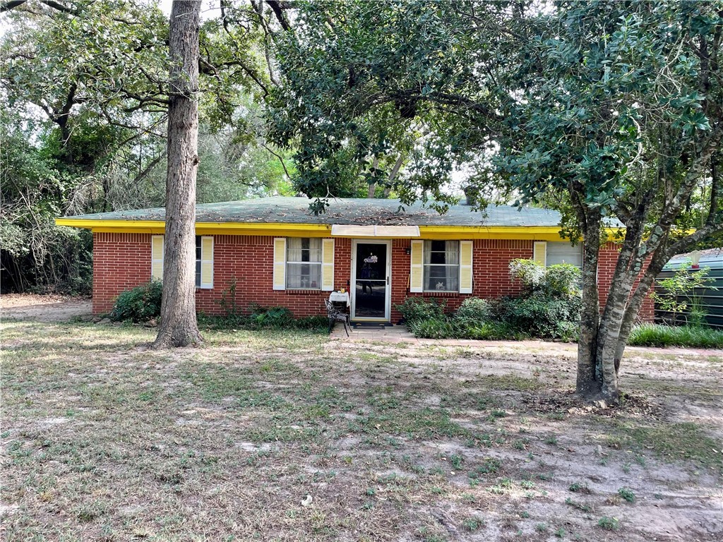 a view of a house with a tree in front of it