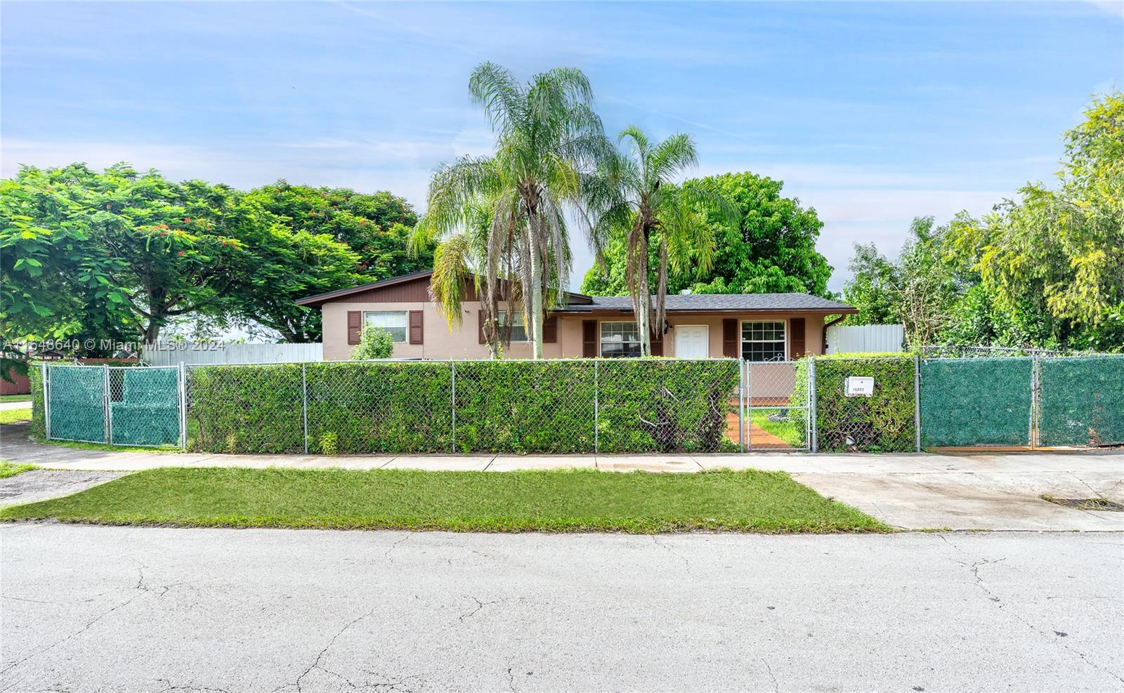 a front view of a house with a yard and potted plants