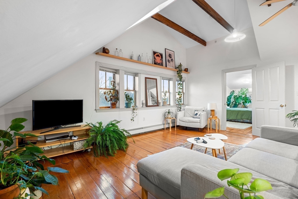 a living room with furniture a window and a flat screen tv