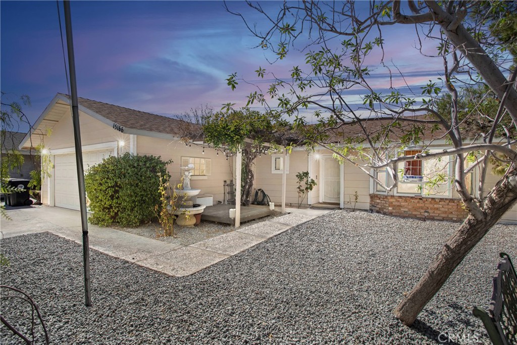 a view of a house with a tree and a yard