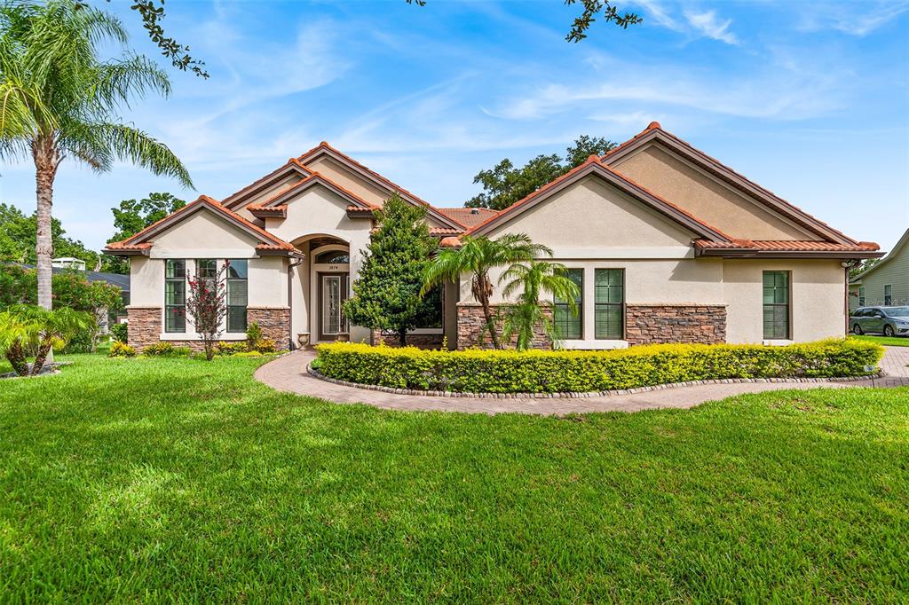 a view of a house with a big yard plants and large trees