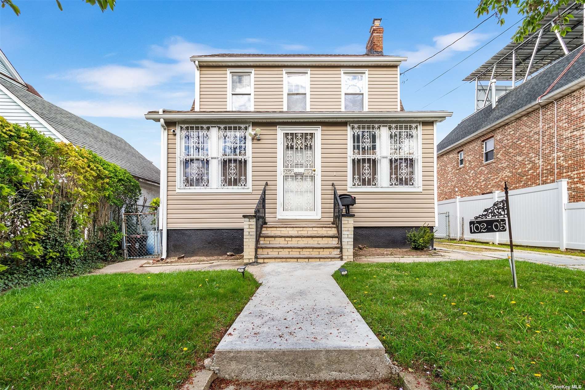 a front view of a house with a yard and fence