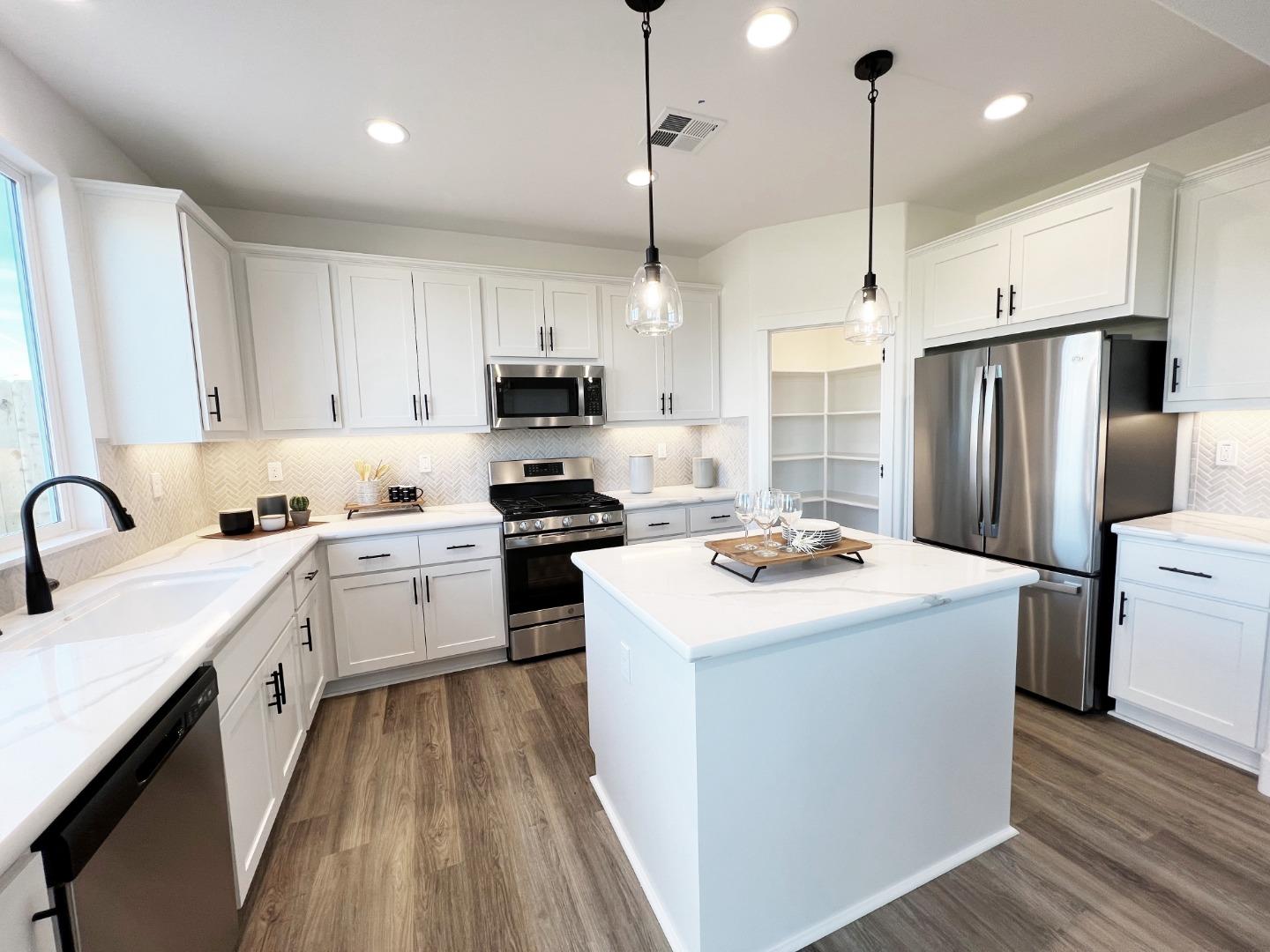 a kitchen with kitchen island a sink appliances and cabinets