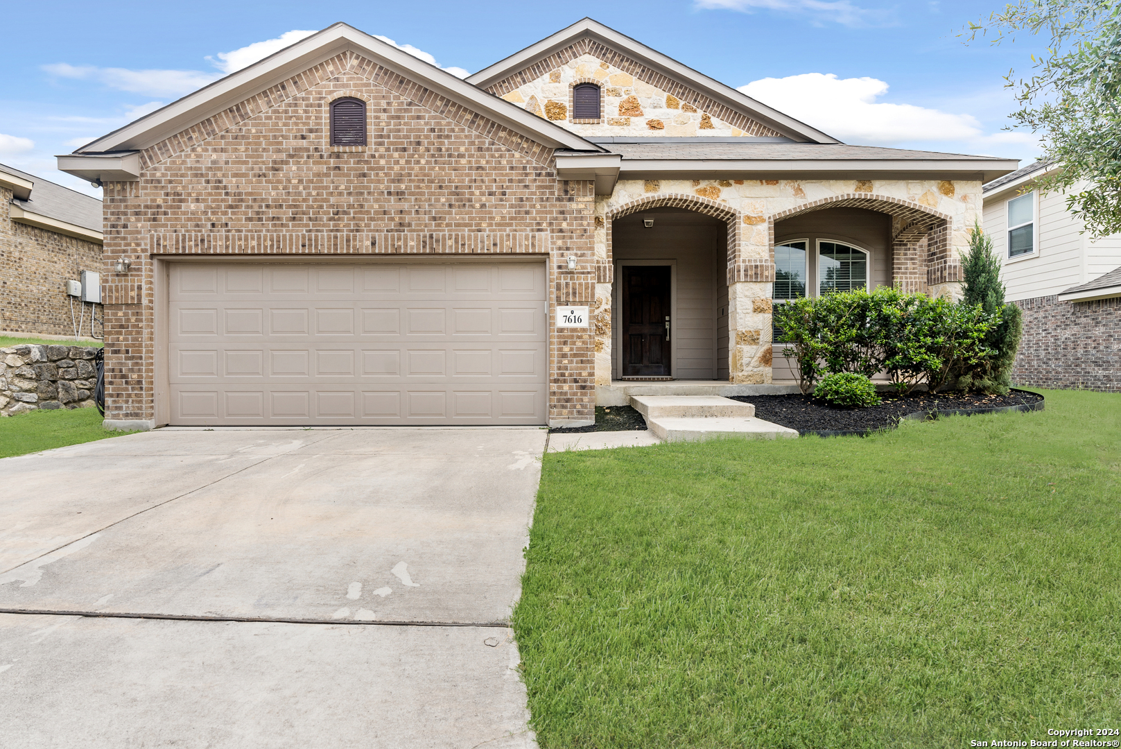 a front view of a house with a yard and garage