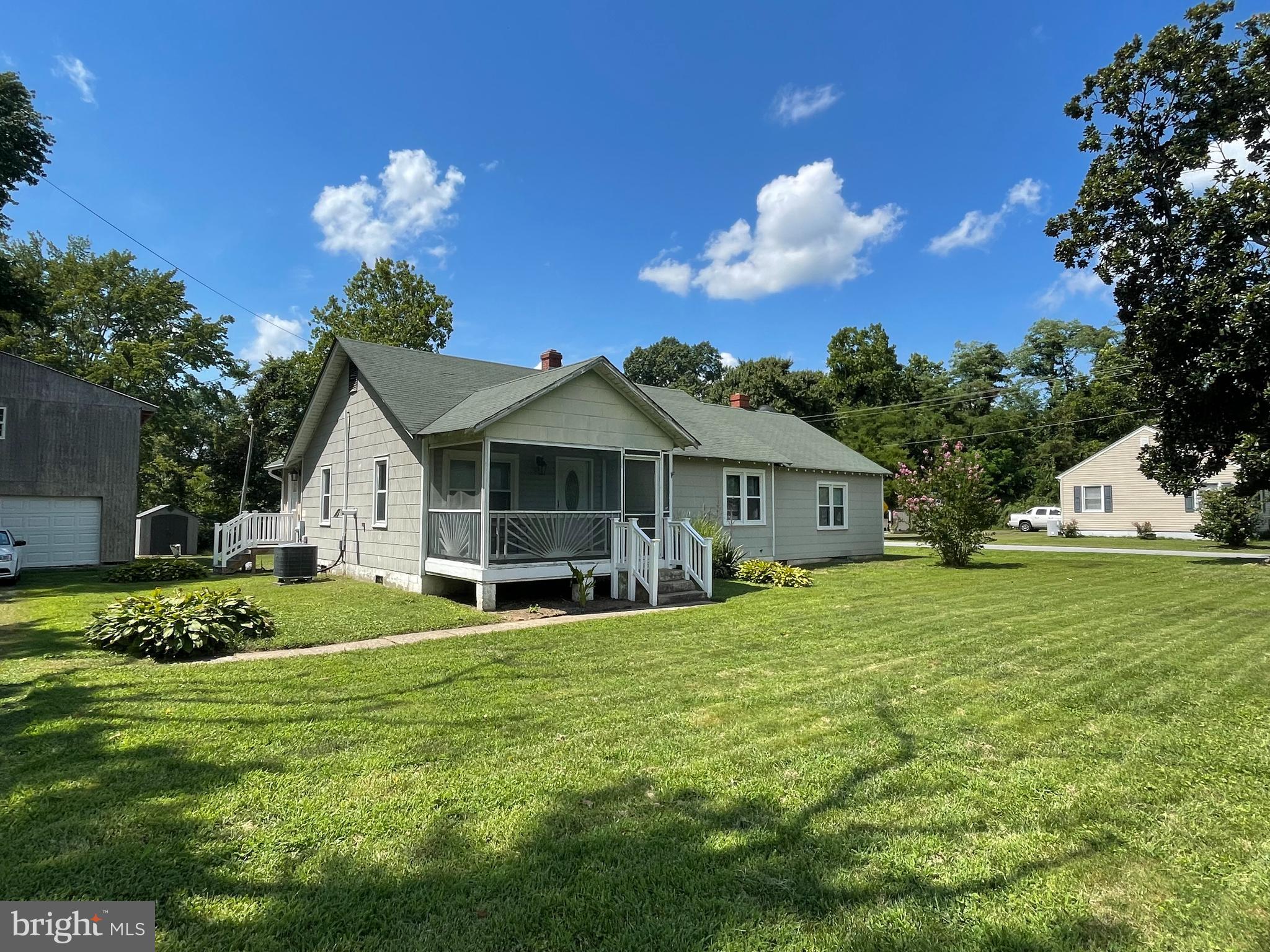 a front view of a house with a garden and trees