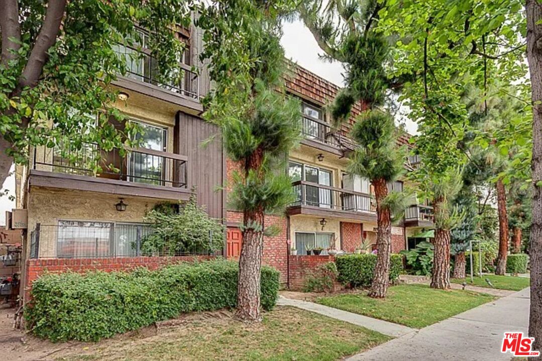 a front view of a residential apartment building with a yard