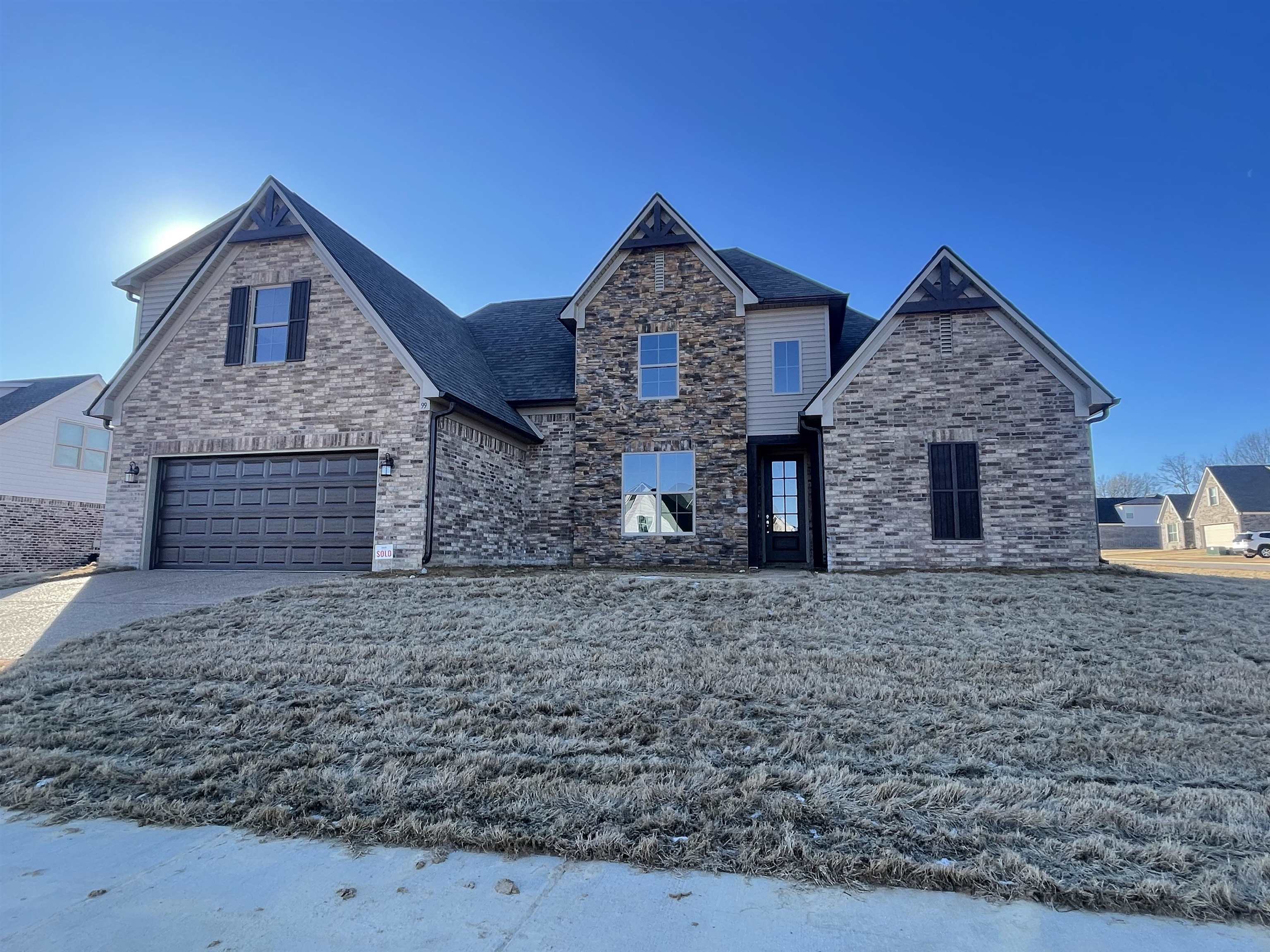 View of front of house featuring a garage and a front lawn