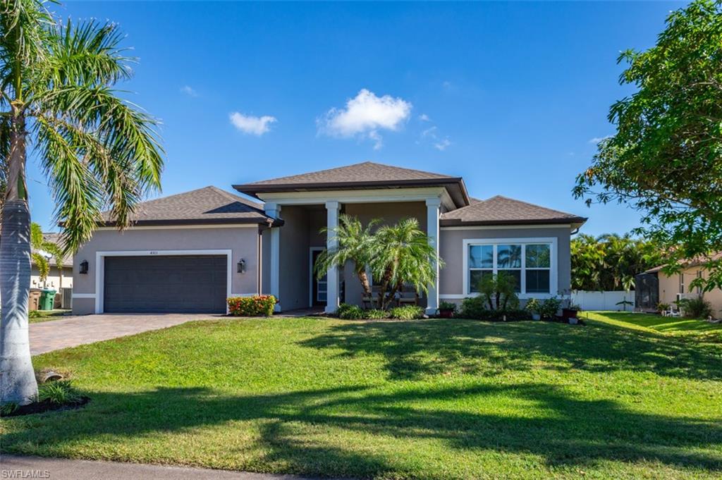 View of front of home featuring a front yard and a garage