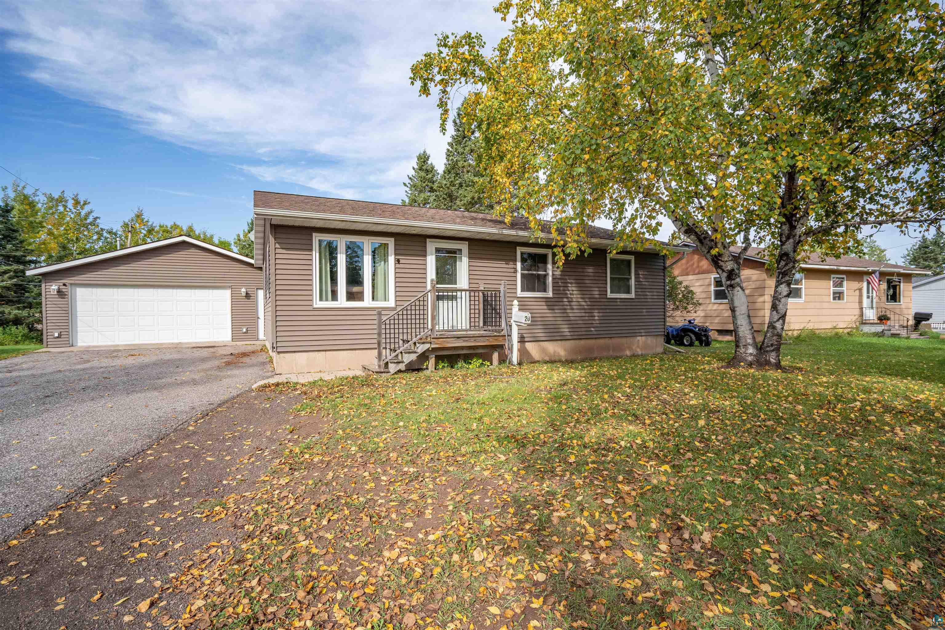 Ranch-style home featuring an outbuilding, a garage, and a front lawn