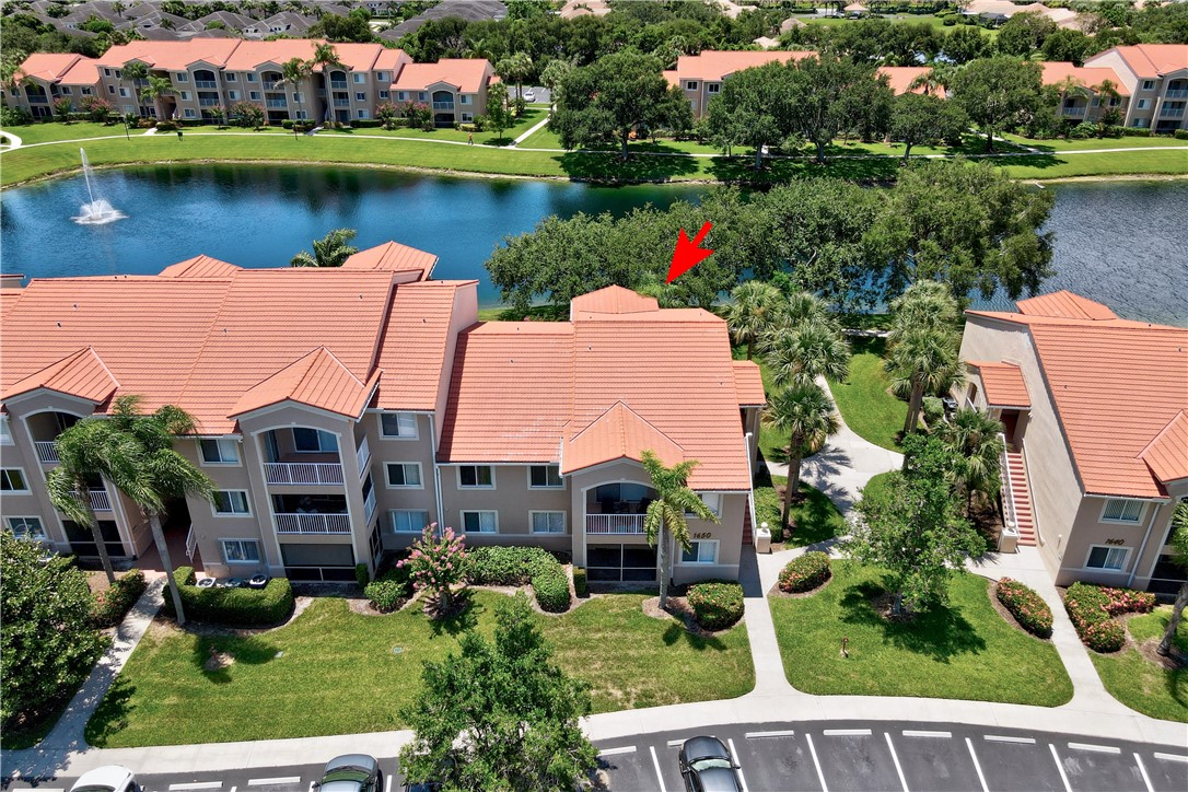 an aerial view of a house with a garden and lake view