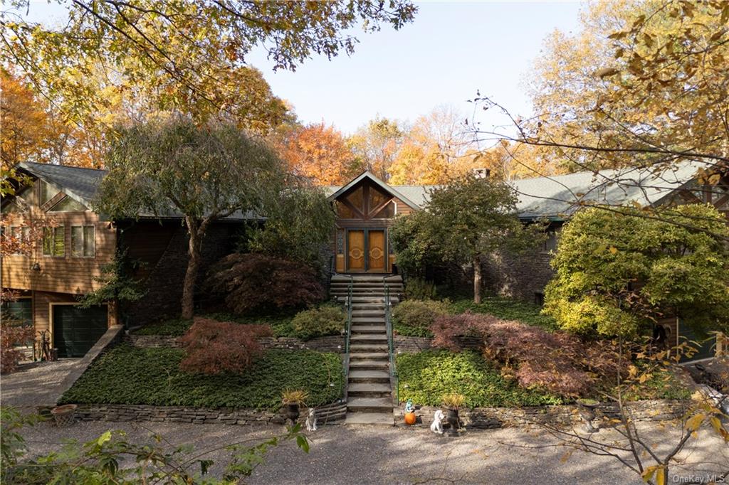 a front view of house with yard and trees in the background