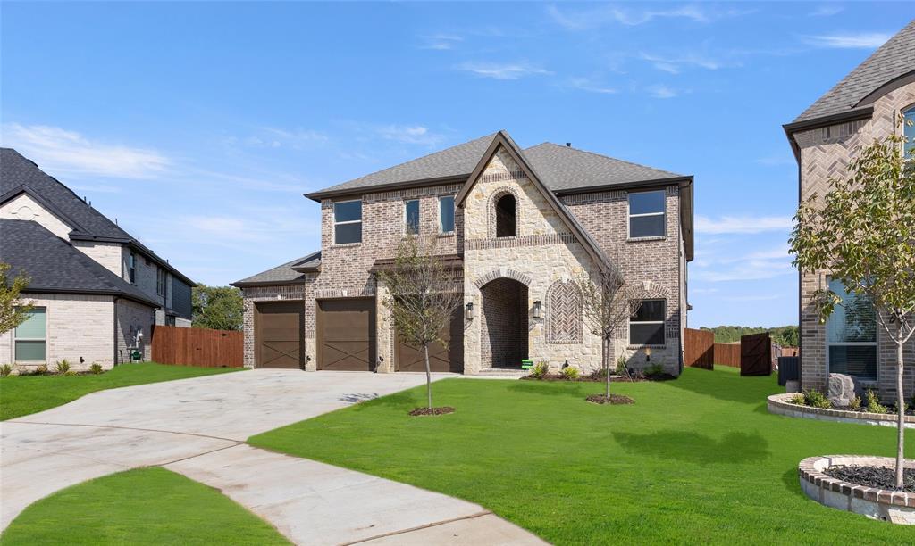 a front view of a house with a garden and yard