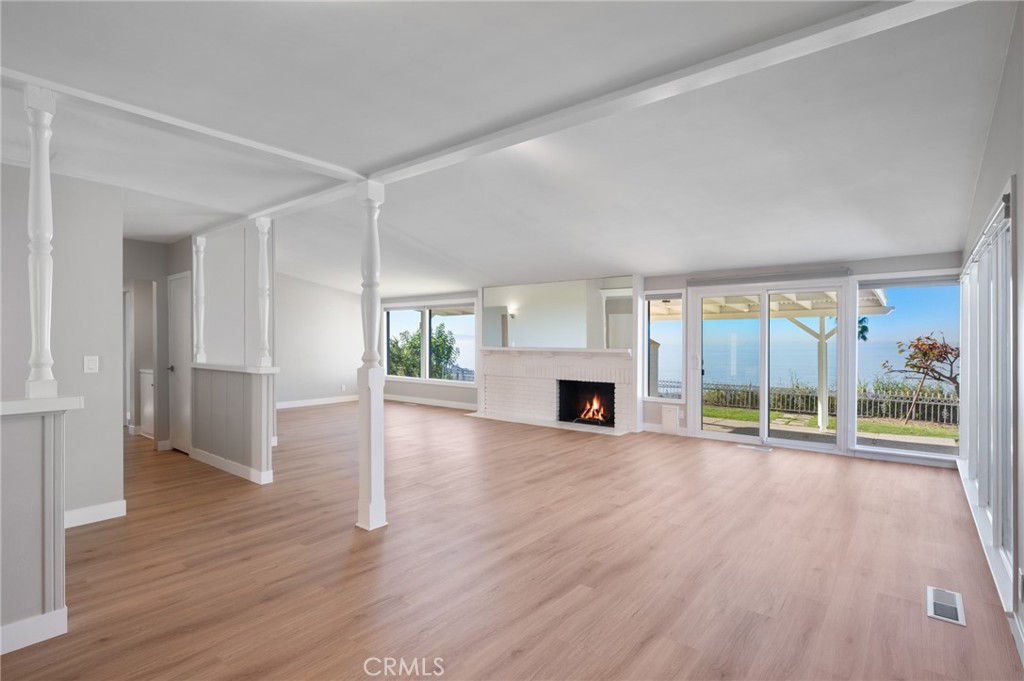 a view of empty room with wooden floor and fireplace