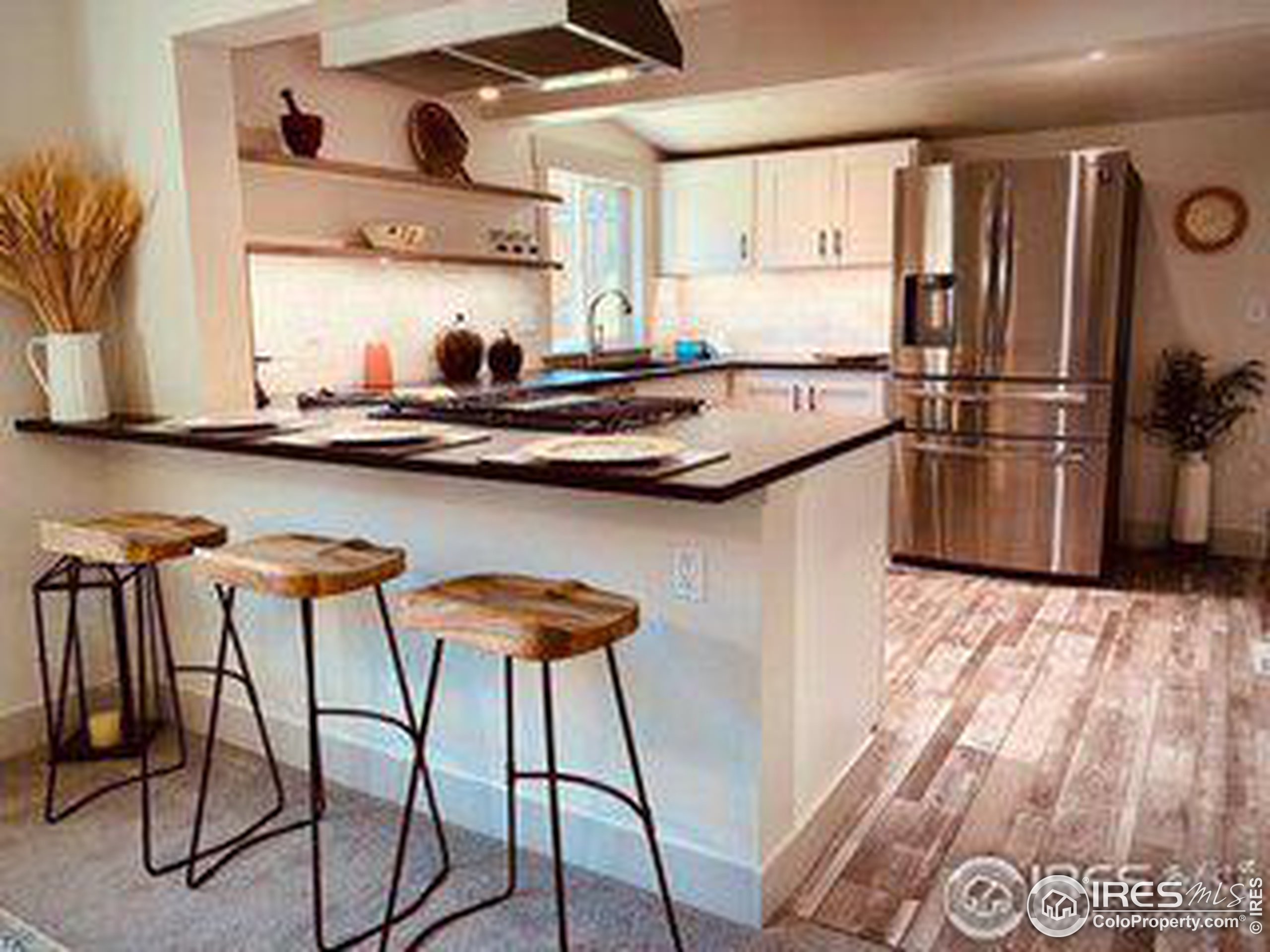 a kitchen with stainless steel appliances granite countertop a sink and chairs in it