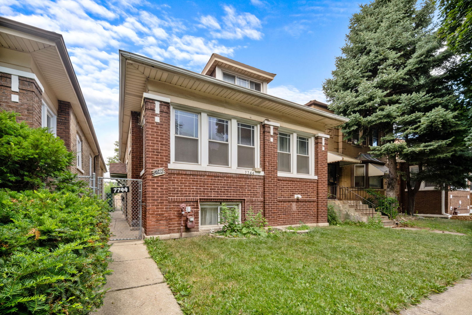 a front view of a house with a garden