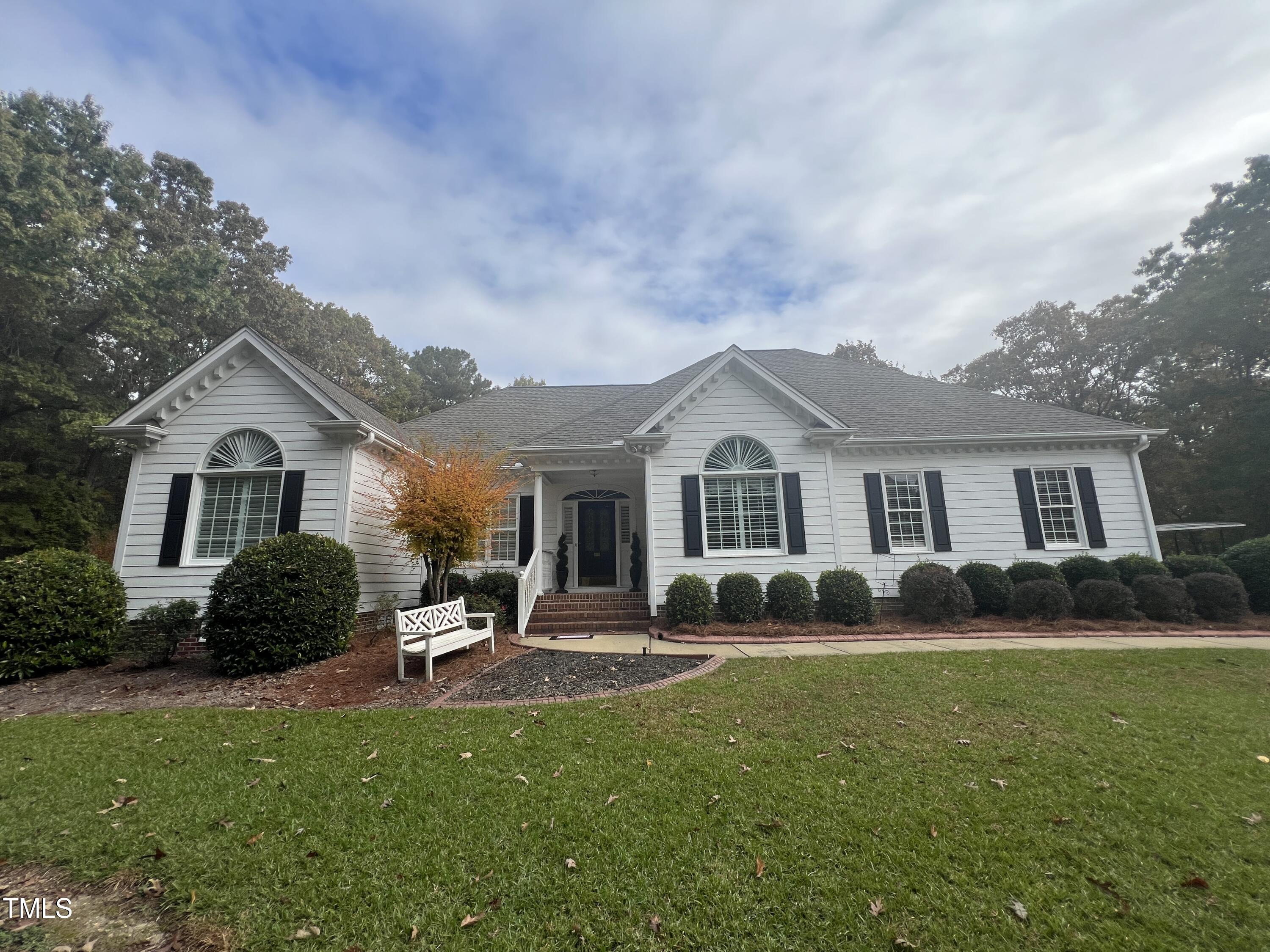 a front view of a house with a yard and trees