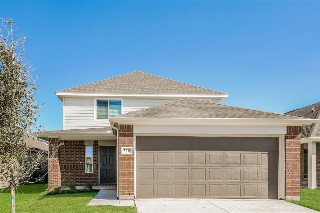 a front view of a house with a yard and garage