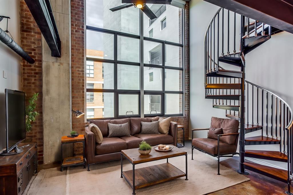 a living room with furniture a flat screen tv and a window