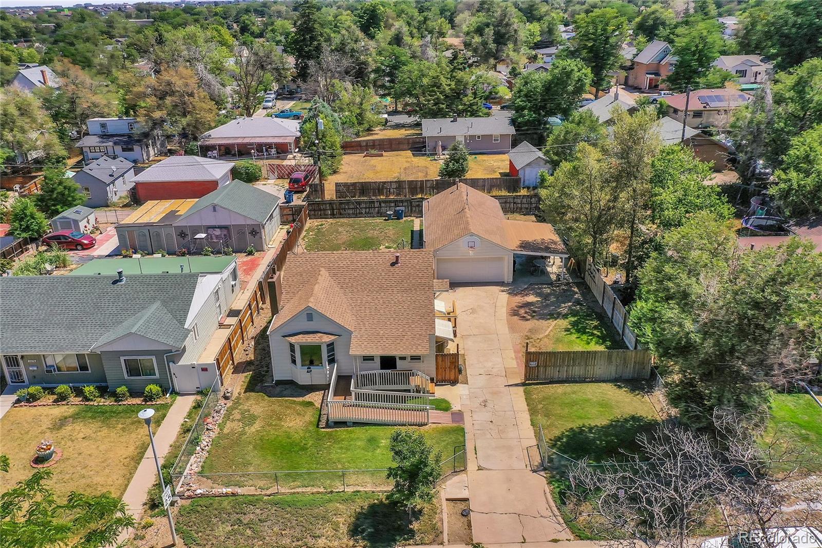 an aerial view of a house with swimming pool and large trees