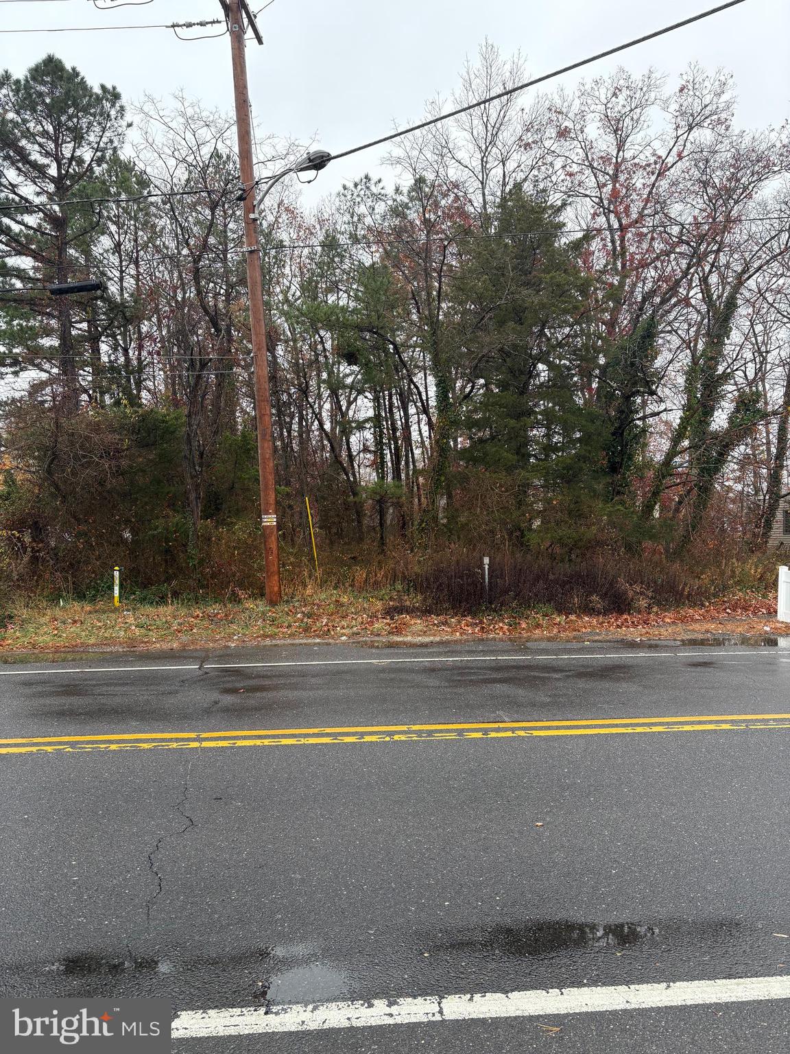 a view of a house with a yard and a car park side of a road