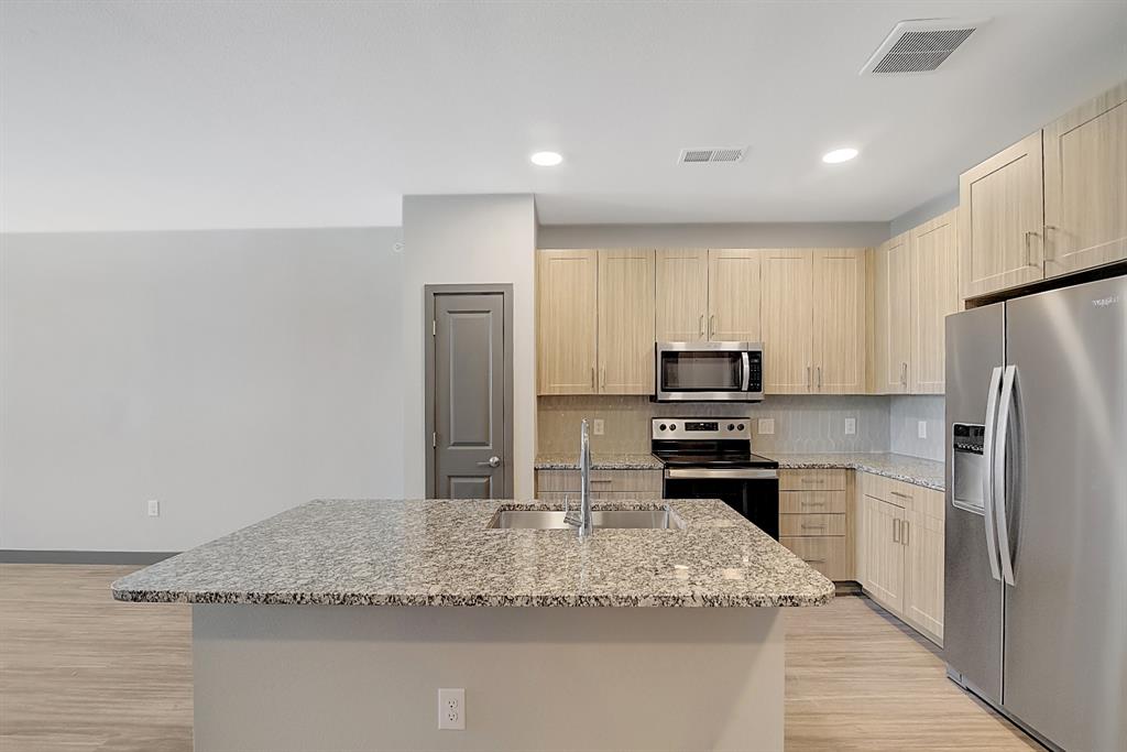 a kitchen with granite countertop a refrigerator and a sink