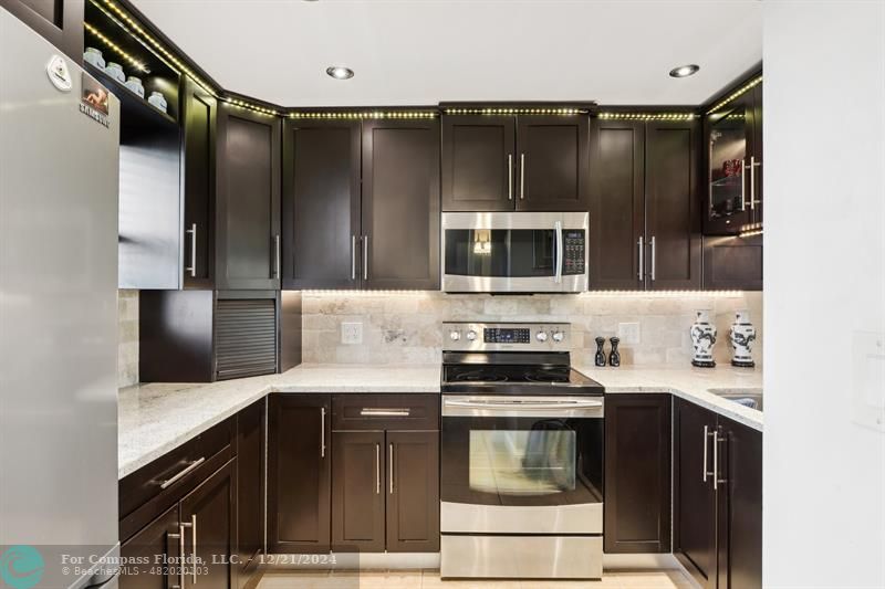 a kitchen with a sink a stove and cabinets