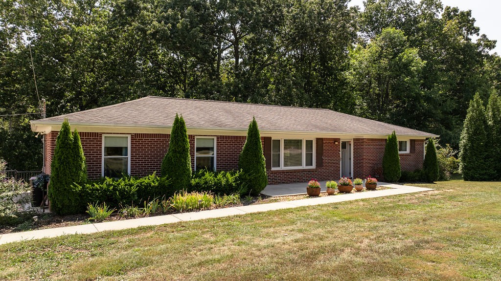 a front view of a house with a yard and tree