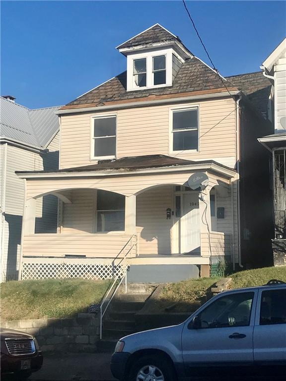 a view of a house with a car parked on road