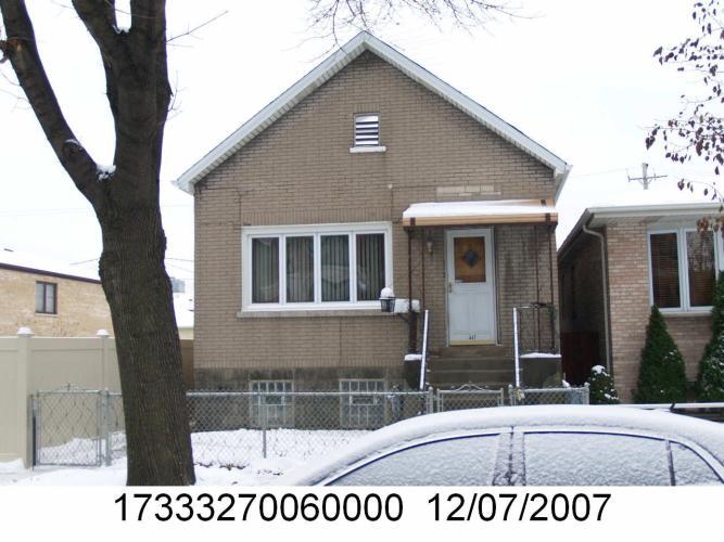 a view of a house with a small yard and large tree