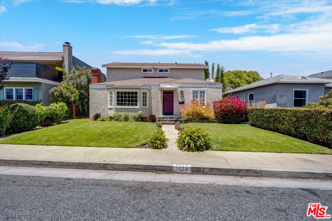 a front view of a house with a garden