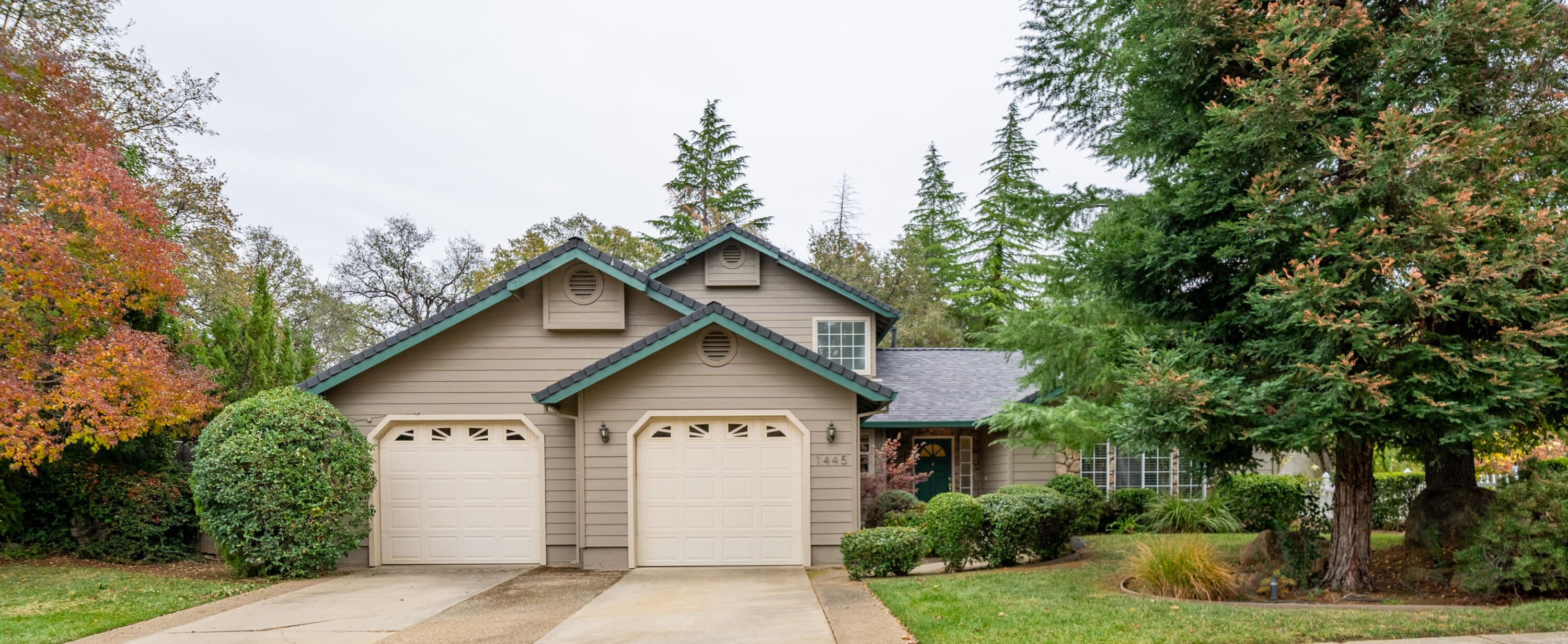 a view of house with yard and trees in the background