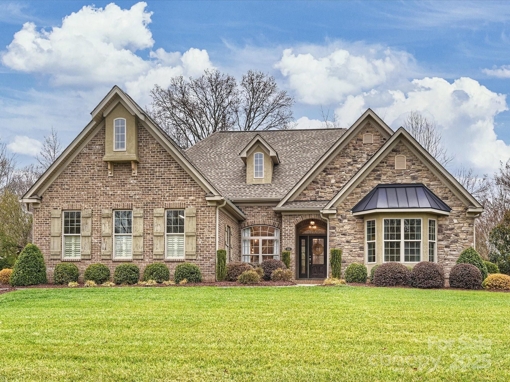 a front view of a house with a garden