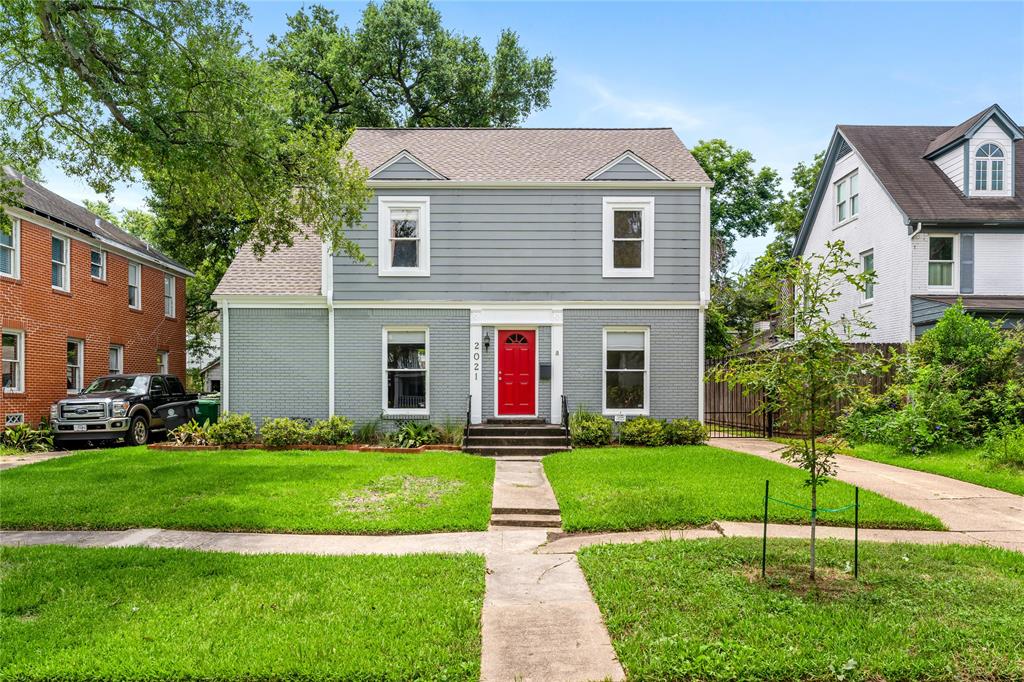 2021 Banks Street with the classic red door welcomes its residents on this beautiful tree-lined street in Boulevard Oaks.