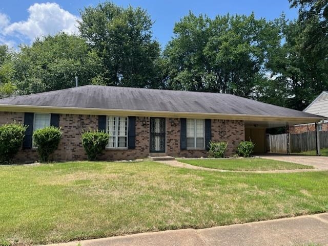 Ranch-style home with a carport and a front yard