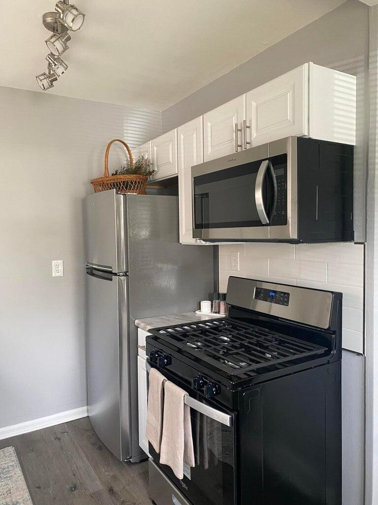 a kitchen with stainless steel appliances granite countertop a stove and a microwave