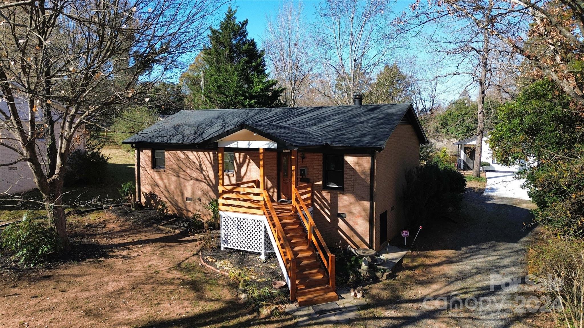 a view of a house with backyard and trees