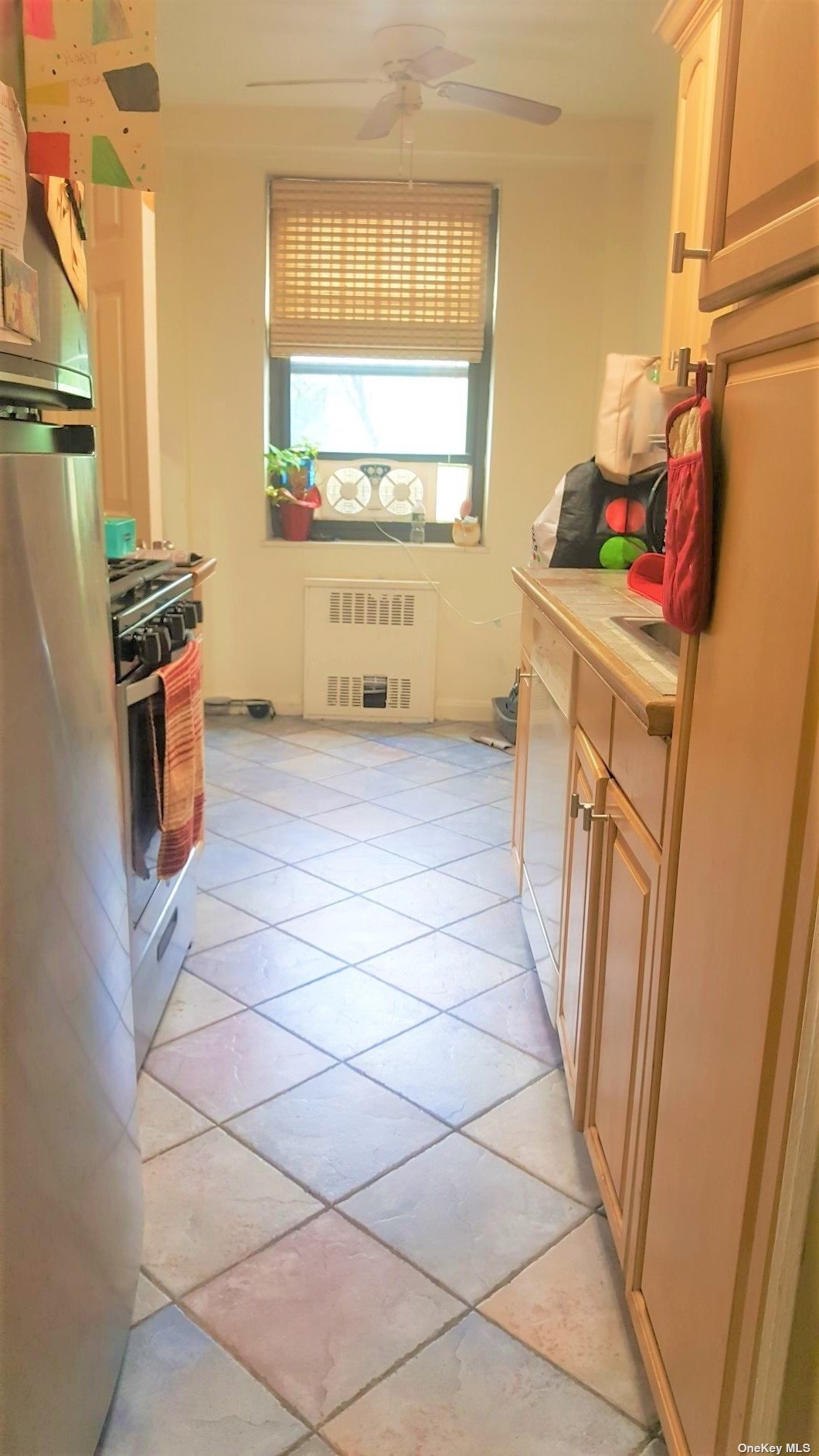 a view of a kitchen with fridge and windows